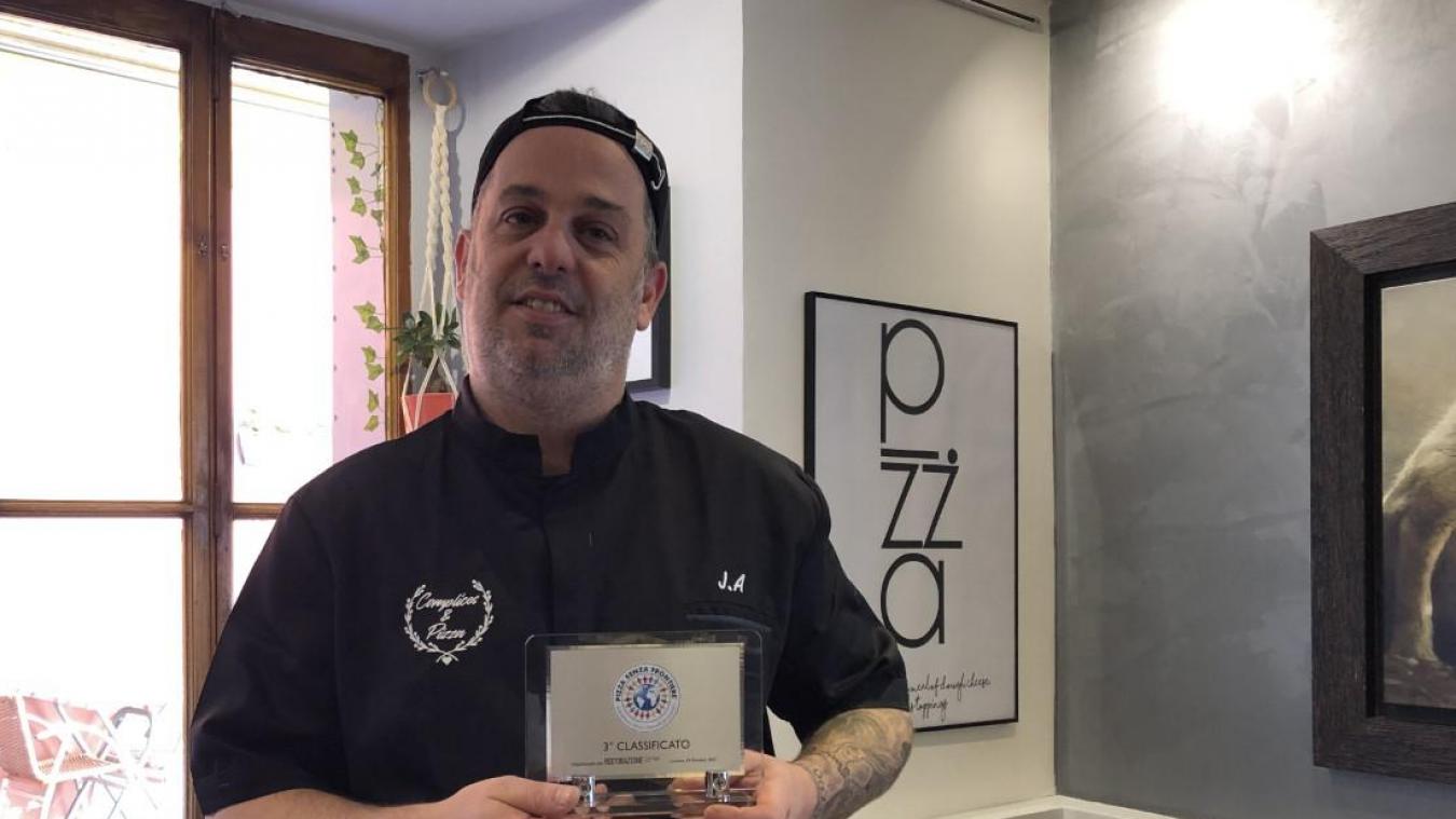 Joris Atoch pose avec son trophée dans les allées de son restaurant, Complices et Pizza.