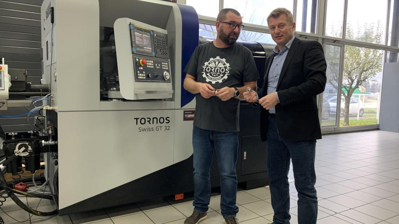 Patrice Arméni, et Mathieu (à g.), responsable de la mise en train des machines, posent devant l’une des dernières innovations de l’entreprise Tornos.