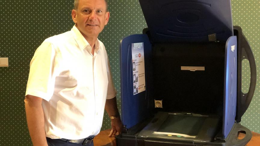 Fabrice Gyselinck pose aux côtés de la machine à voter, trop en avance sur son temps !