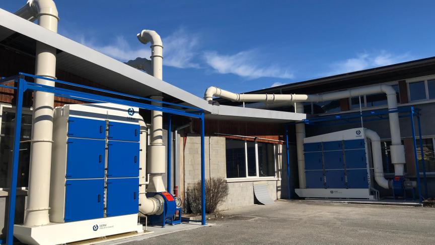 Le nouveau système de filtration est visible depuis le parking de l’enteprise. À droite, les fumées émises avant l’installation du nouveau système.