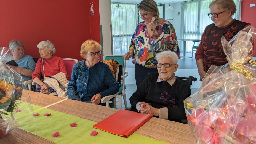 Thérèse Chevrat, assise à droite avec un cahier devant elle,célèbre ses 107 ans avec le sourire.